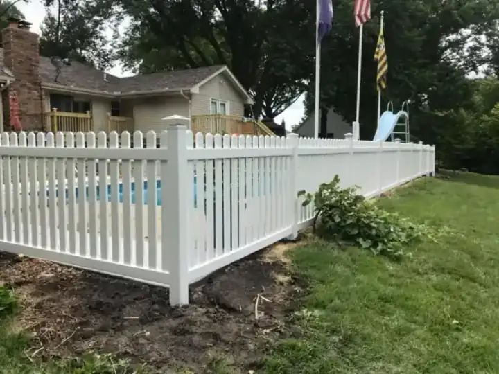 White vinyl picket pool enclosure around an in-ground pool