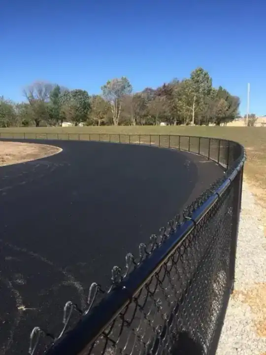 Black chain link along a curved commercial running track