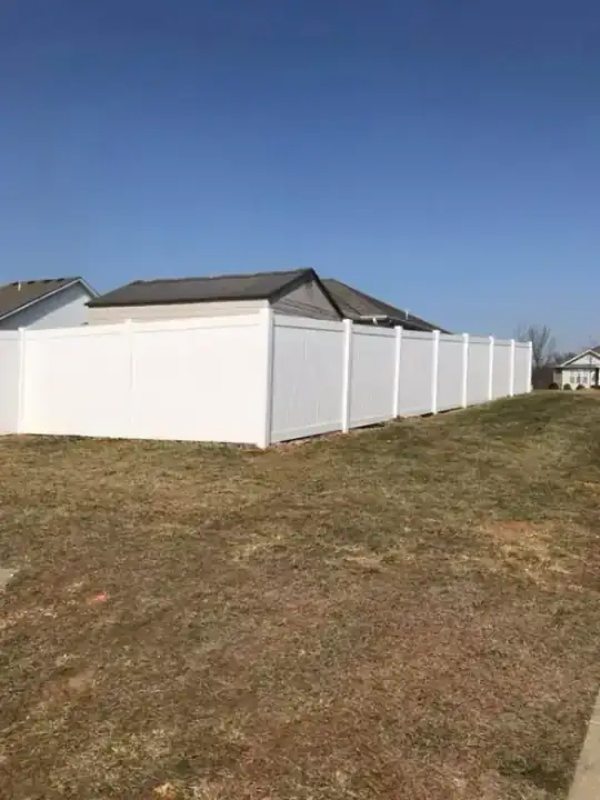 White vinyl privacy fence on a new build lot