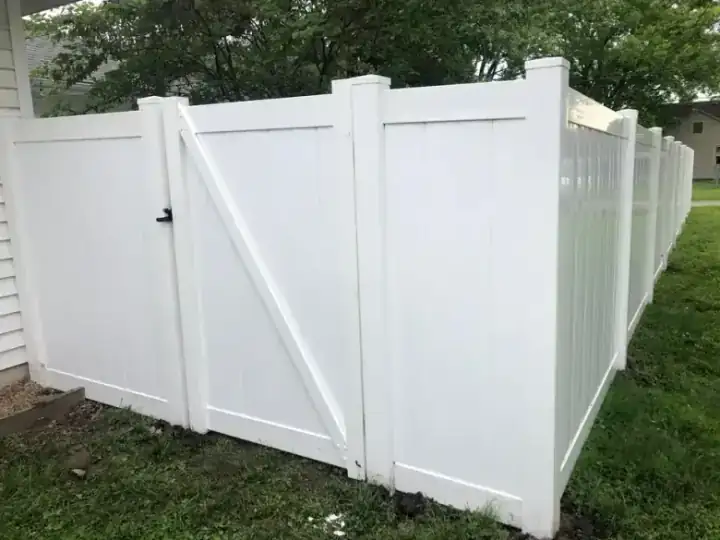 White vinyl privacy fence with a matching gate on a residential property